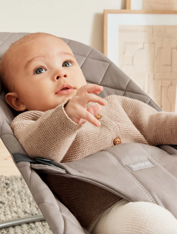 babybjorn-babysitter-bliss-cotton-sand-grey. BabyBjörn Bliss babysitter. Överdrag av bomullstyg som enkelt kan tas av och tvättas i maskin. BabyBjörn Bliss sitter har tre lägen för användning och en hopfällbar position för transport och förvaring.