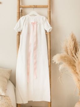 Klione vit barndopsklänning Kotitie för dop eller namngivning. Dopklänningens framsida har en vacker spets och baksidan har en knappning.